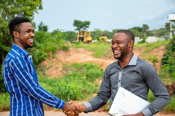 young african modern farmers shake hands, satisfied with a deal