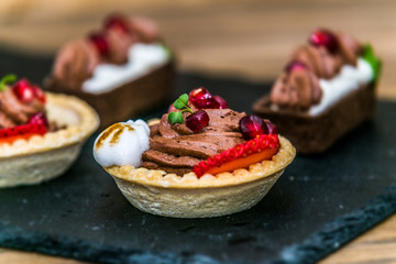 Sweet dessert Tartlets with different fresh fruit and delicious cream. Closeup