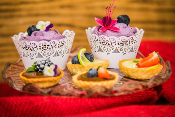Fototapeta na wymiar Sweet dessert Tartlets with different fresh fruit and delicious cream. Closeup
