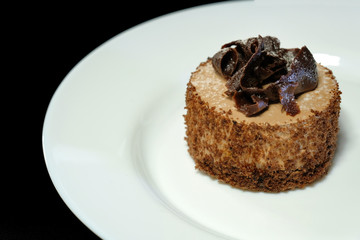 Fototapeta na wymiar A serving of chocolate cake in a plate, closeup. Sweet dessert.