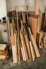 Chunks and pieces of wood leaning against the wall of a carpentry, a wood workshop