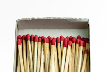 Close-up of many red face matches in the box on a white background