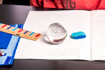 Student with crystal ball on his math notebook before the exam