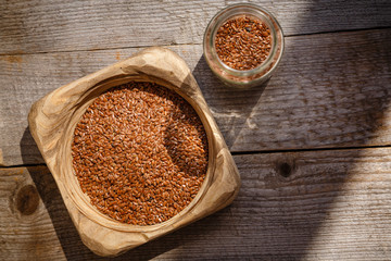 Flax seeds in a wooden bowl on a wooden table