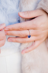 Fototapeta premium Close up of a woman's hand with blue sapphire engagement ring