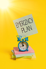 Handwriting text Emergency Plan. Conceptual photo procedures for handling sudden or unexpected situations Metal alarm clock blank sticky note stacked notepads colored background