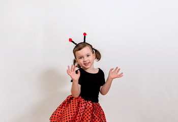 Funny blonde girl in a ladybug costume on a white background with space for text.