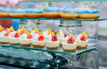 
Catering with pink and blue donuts at a celebration Baby Shower. Cakes with raspberries and lemon...