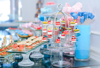 Unusual table setting made of desserts in a metal construction. Holiday catering with sweets and 
with bread baguettes and smoked salmon