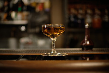 manhattan cocktail in bar with brack cherry