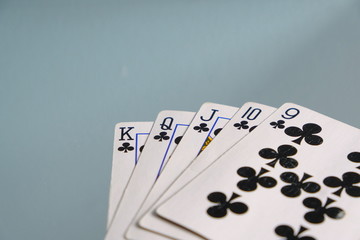 Club Straight Flush Playing Cards. Five card hands. Nine, Ten, jack, queen, king on blue grey background. Poker hand and card games. Club suit almost a royal flush, gambling. Las Vegas