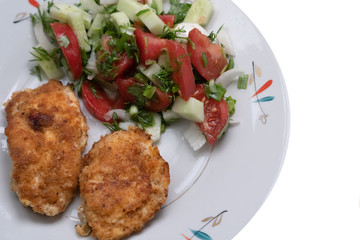 Fried chicken slices in breadcrumbs with salad on a plate