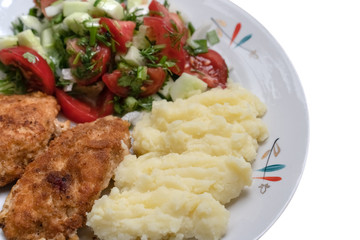 Fried chicken slices in breadcrumbs with salad and mashed potatoes