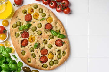 Focaccia traditional italian bread with cherry tomatoes and olives.  Homemade baking. Top view. Copy space