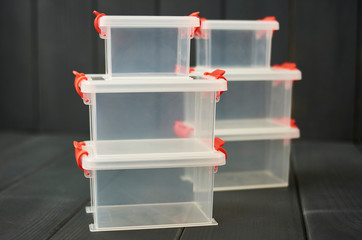 Plastic storage boxes for objects stacked and on wooden floor