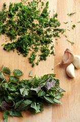 nettle green and garlic on wooden board 