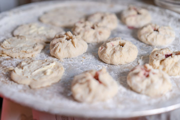 Preparing a pastry for baking buns with jam