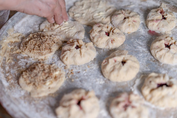 Preparing a pastry for baking buns with jam