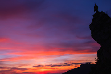 Silhouette d’un photographe au,sommet d’une montagne avec un magnifique coucher de soleil en arrière plan 