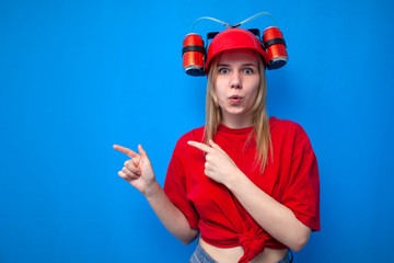 surprised funny girl female fan in red uniform shows fingers to place for text, shocked cheerleader on blue background