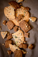 chocolate and white cookies with sunflower seeds and sesame seeds on a brown background, top view