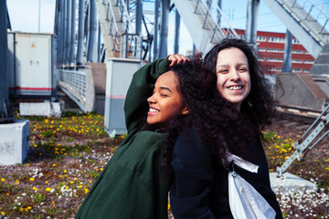 young cute teenage girls together in industrial zone happy smiling having fun, big city lifestyle...