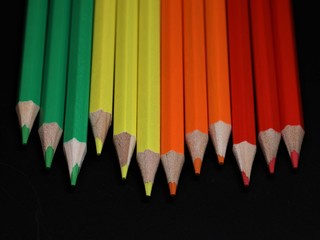 Reihe Buntstifte in grün, gelb, orange und rot
