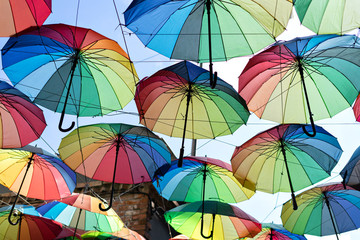 Fototapeta na wymiar Background colorful rainbow different color umbrellas. unban tourist street decoration.