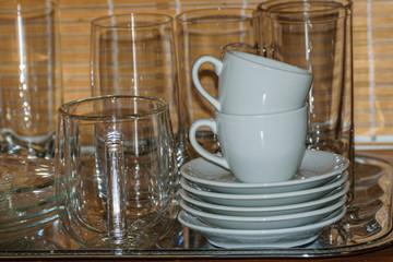 a tray with clean dishes and glasses in a small family cafe in the kitchen.