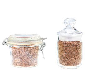 Glass jar with flax seeds isolated on a white background.