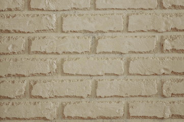 light beige imitation of a brick wall with a pattern of aged shabby brick. wall decoration with decorative elements