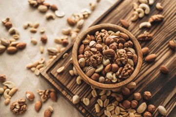 Different types of nuts, nut mix of almonds, hazelnuts, cashews, peanuts on a wooden bowl. Close up