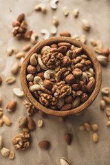 Different types of nuts, nut mix of almonds, hazelnuts, cashews, peanuts on a wooden bowl. Close up