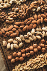 Different types of nuts, nut mix of almonds, hazelnuts, cashews, peanuts on a wooden board. Close up