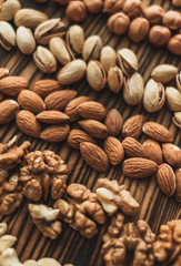 Different types of nuts, nut mix of almonds, hazelnuts, cashews, peanuts on a wooden board. Close up