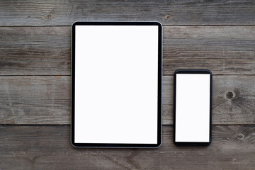 Smartphone and tablet with white screen on old wooden background
