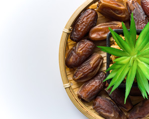 Dates or kurma on white background with flower pot, the favorite food of the holy ramadhan month.