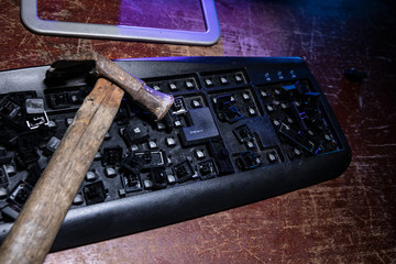Hammer on computer keyboard with damaged keys