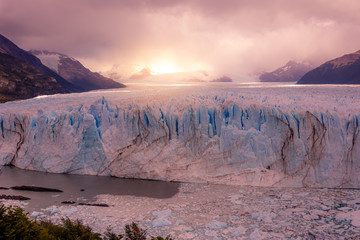 lake in the middle of a glacier with pieces of icebergs coming out of the water