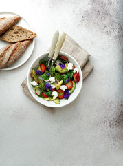Obraz na płótnie Canvas fresh summer salad of arugula, avocado, radish and strawberries and edible flowers, olive oil.