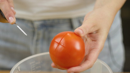 Woman cuts vegetables for salad. Cut tomatoes closeup. The concept of a healthy lifestyle