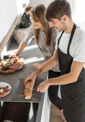 young couple having fun making sandwiches for Breakfast.