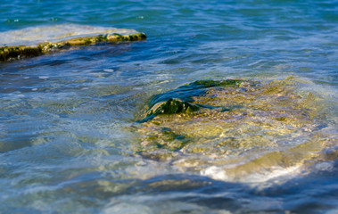 rocky sea shore with pebble beach, waves with foam