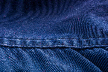 clothing items stonewashed cotton fabric texture with seams, clasps, buttons and rivets, macro