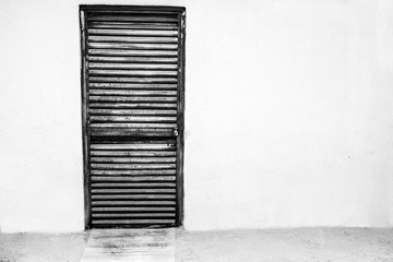 Puerta metalica vintage con pared blanca en blanco y negro