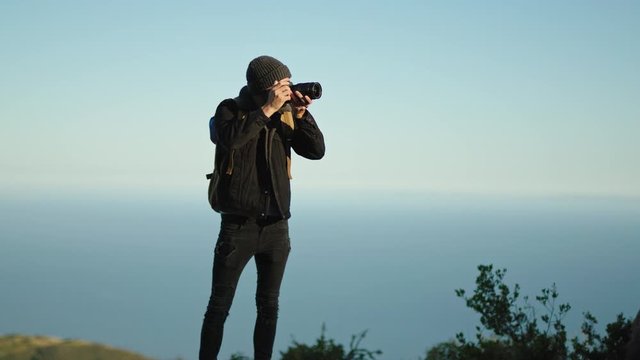 Photographer hiking at California Pacific Coast and shooting landscapes, active hobby, professional photography