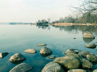Large round beautiful natural stones cobblestones in water, sea, lake, river. Background, texture