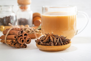Star anise, cinnamon sticks, cardamom, bay leaf, pepper and other ingredients for making masala tea on a white wooden table