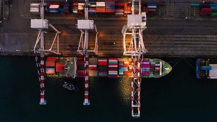 time lapse day to night Cargo container ships loading cargo with cranes in the international container yard port. 

