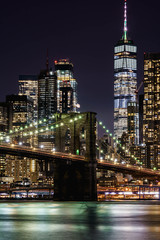 Fototapeta na wymiar New York night panorama. Brooklyn Bridge and New York City skyline. Manhattan skyline. Skyscrapers buildings. New York City night lights. 